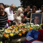 Ofelia Acevedo, wife of Oswaldo Paya, one of Cuba's best-known dissidents, places a rose on the tomb of her husband during his burial in Havana