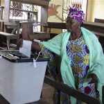 A woman casts her ballot at a polling station in Guinea's capital Conakry