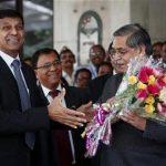 Newly appointed governor of RBI Rajan receives a bouquet from RBI deputy governor Chakrabarty in Mumbai