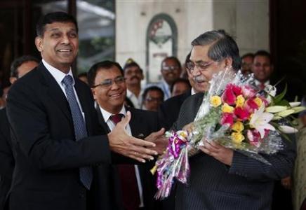 Newly appointed governor of RBI Rajan receives a bouquet from RBI deputy governor Chakrabarty in Mumbai