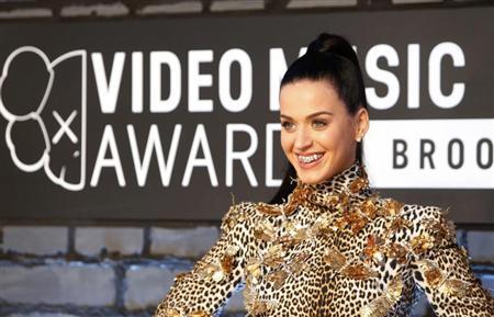 Singer Katy Perry shows off her bejeweled teeth on arrival for the 2013 MTV Video Music Awards in New York
