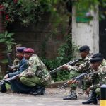 Police officers take position during the ongoing military operation at the Westgate Shopping Centre in Nairobi