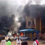 Cars burn in front of a building during protests over fuel subsidy cuts in Khartoum