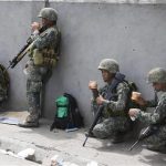 Members of Philippine Marines eat a meal at their positions on the fourth day of a government stand-off with the MNLF rebels in downtown Zamboanga city