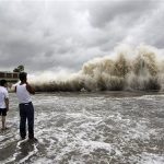People watch waves hit the shores as Typhoon Usagi approaches in Shantou