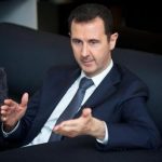 Syria's president Bashar al-Assad gestures during an interview with French daily Le Figaro in Damascus