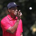 Tiger Woods catches a ball before his putt from his caddie on the second hole at the Tour Championship golf tournament in Atlanta
