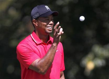 Tiger Woods catches a ball before his putt from his caddie on the second hole at the Tour Championship golf tournament in Atlanta
