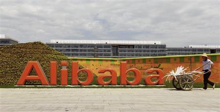 A worker walks past a logo of Alibaba Group at its headquarters on the outskirts of Hangzhou