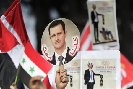 A student holds a sign with a picture of Syria's President Bashar al-Assad during a protest by a students' national union against possible U.S. military action in Syria, in Brasilia