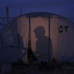 Shadows of Syrian refugees in a tent are seen at Bab al-Salam refugee camp in Azaz
