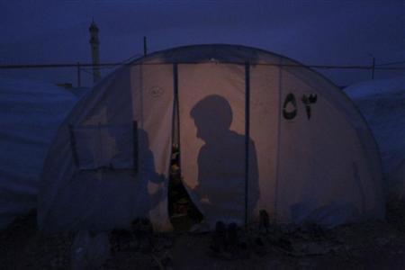 Shadows of Syrian refugees in a tent are seen at Bab al-Salam refugee camp in Azaz