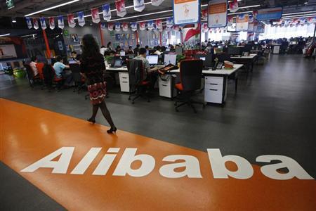 File photo of an employee walking past a logo of Alibaba Group at its headquarters on the outskirts of Hangzhou