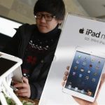 A student tries Apple Inc's iPad mini at an electronics store in central Seoul