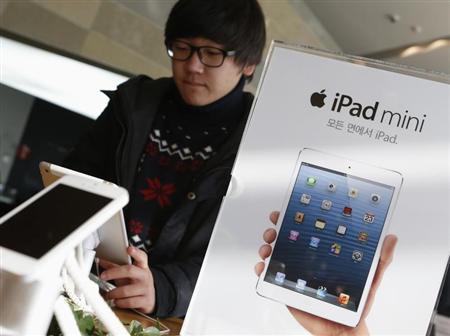 A student tries Apple Inc's iPad mini at an electronics store in central Seoul
