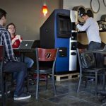 Vancouver Bitcoiniacs Trading Company co-founder Demeter prepares, according to him, the first bitcoin ATM machine in a Waves Coffee House in Vancouver