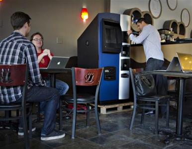 Vancouver Bitcoiniacs Trading Company co-founder Demeter prepares, according to him, the first bitcoin ATM machine in a Waves Coffee House in Vancouver