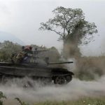 A Congolese armed forces tank fires a shot as soldiers battle M23 rebels in Kibati