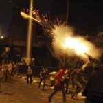 A riot police officer fires tear gas during clashes between anti-Mursi protesters, and members of the Muslim Brotherhood and ousted Egyptian President Mohamed Mursi supporters, in Cairo