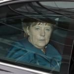 German Chancellor Merkel sits in her limousine as she leaves first round of coalition talks in Berlin