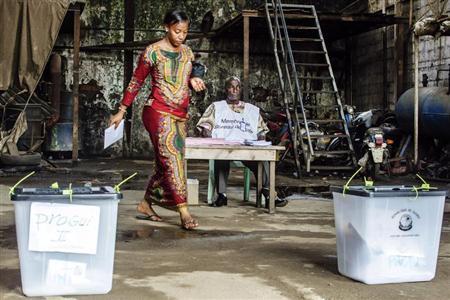 A voter prepares to cast her ballot at a polling station in Conakry