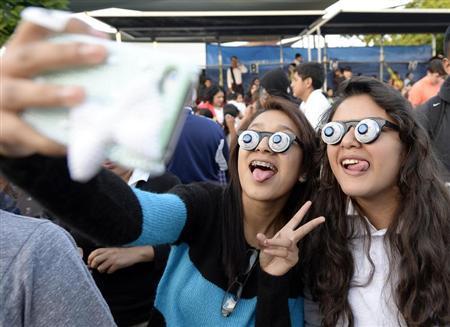 Children take pictures during an attempt to break a world record for largest gathering of people wearing googly eye glasses at a Halloween party in Los Angeles