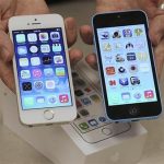 An employee shows the the front of a new Apple iPhone 5C and iPhone 5 S at a Verizon store in Orem, Utah