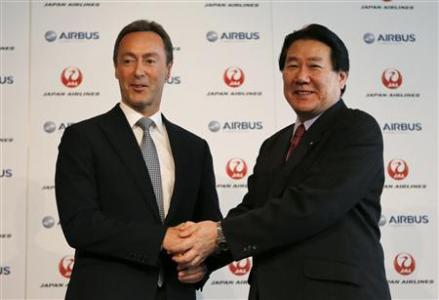 Japan Airlines President Yoshiharu Ueki shakes hand s with Airbus Chief Executive Fabrice Bregier during their joint news conference in Tokyo