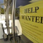 A help wanted sign is posted on the door of a gas station in Encinitas, California