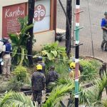 Foreign forensic experts, flanked by Kenyan military personnel, check the perimeter walls around Westgate shopping mall in Nairobi