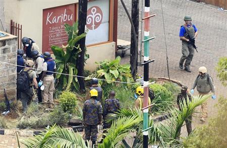 Foreign forensic experts, flanked by Kenyan military personnel, check the perimeter walls around Westgate shopping mall in Nairobi