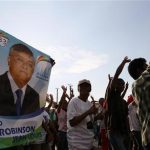Supporters of Madagascar's Presidential candidate Jean-Louis hold his poster and cheer during a post-election rally in the capital Antananarivo
