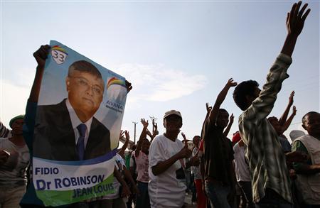Supporters of Madagascar's Presidential candidate Jean-Louis hold his poster and cheer during a post-election rally in the capital Antananarivo