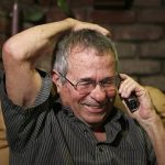 University of Southern California professor Warshel talks on the phone with Israeli President Peres after hearing he won the Nobel chemistry prize in Los Angeles, California