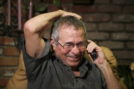 University of Southern California professor Warshel talks on the phone with Israeli President Peres after hearing he won the Nobel chemistry prize in Los Angeles, California