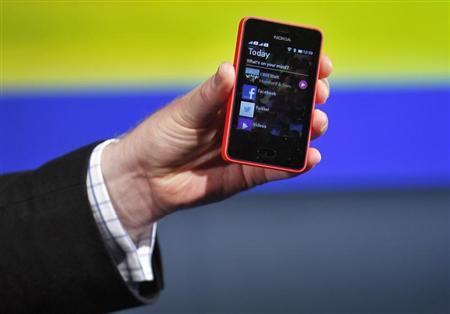 A Nokia official displays a new $99 phone in its mid-range Asha line at a launch in New Delhi
