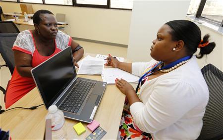 A Certified Application Counselor takes information from woman inquiring about Affordable Care Act insurance in Miami