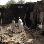 Residents stand inside damaged house after missile attack in Damadola village of Bajaur tribal region in Pakistan