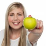 Smiling Girl Displaying Fresh Green Apple