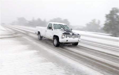 A pickup drives on Highway 44 as heavy snow falls in Rapid City