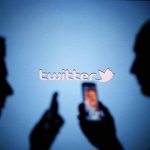 Men are silhouetted against a video screen with a Twitter logo as they pose with Samsung S3 and S4 smartphones in this photo illustration taken in the central Bosnian town of Zenica in this file photo