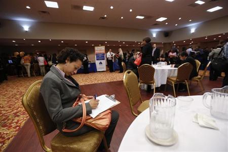 Woman fills out a job application as she attends a job fair in New York