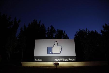 The sun rises behind the entrance sign to Facebook headquarters in Menlo Park before the company's IPO launch,