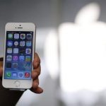 A woman holds her new Apple iPhone 5S after buying it at an Apple Store at Tokyo's Ginza shopping district