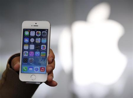 A woman holds her new Apple iPhone 5S after buying it at an Apple Store at Tokyo's Ginza shopping district