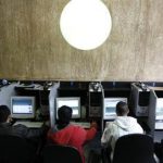 Customers use computers at an internet cafe in Sao Paulo