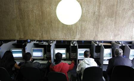Customers use computers at an internet cafe in Sao Paulo