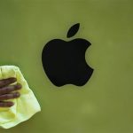 A worker wipes a poster advertisement for Apple's iPhone 5C on a wall of Japan's biggest mobile phone operator NTT Docomo Inc shop before its launch ceremony for the start of the selling of Apple's iPhone 5S and 5C at its shop in Tokyo