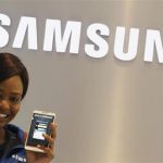 A Samsung employee holds a mobile phone at a Samsung display store in Johannesburg