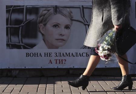 A woman walks past a portrait of jailed former Ukrainian PM and opposition leader Tymoshenko at a protest tent camp set up by her supporters in central Kiev